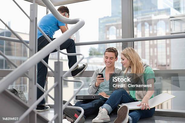 Carpetas Y La Universidad Los Estudiantes Con Teléfono Celular En Las Escaleras Foto de stock y más banco de imágenes de 20-24 años