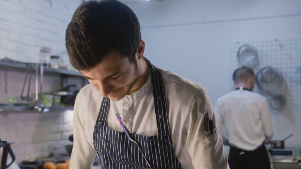 istock Professional chef stands by kitchen table and making food 1483150967
