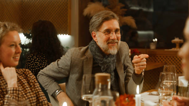 istock Mature man sits in modern cafe with friends 1483153240