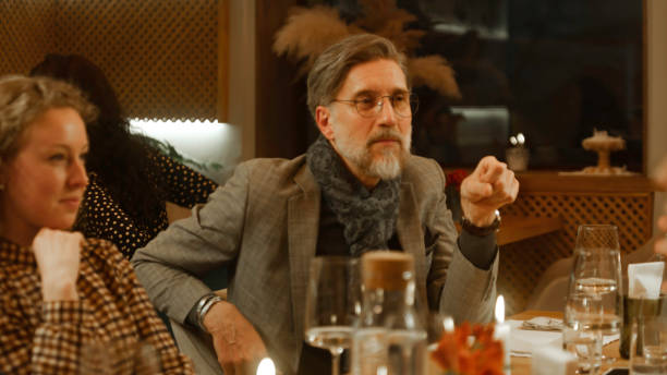 istock Mature man sits in modern cafe with friends 1483153350