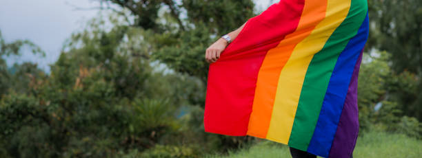 istock LGBTIQ+ community couples outdoors with the flag and sharing smiles. 1483157524