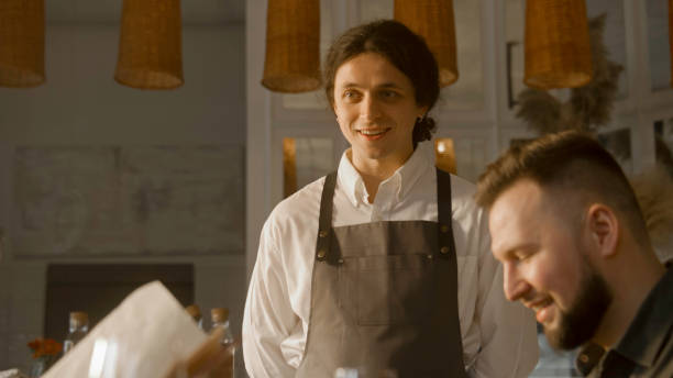 istock Guests watching menu and talking with waiter 1483159117