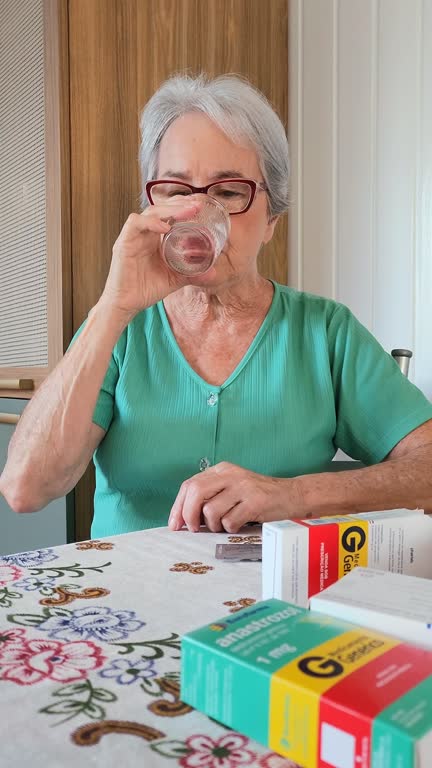 70 year old white lady with white hair taking a pill