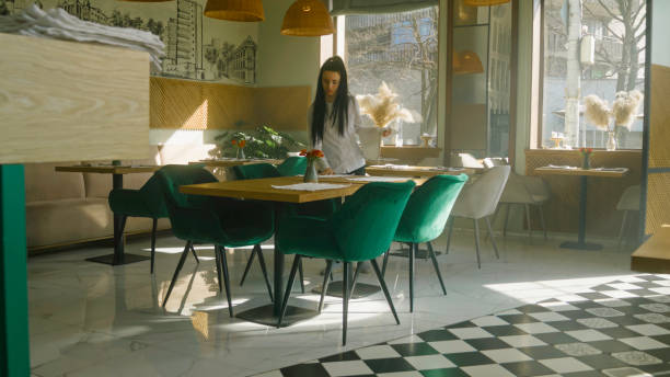 istock Waitress in uniform sets the tables in cafe 1483163789