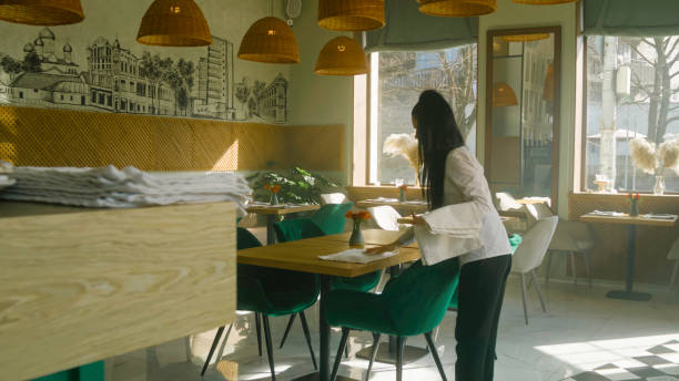 istock Waitress in uniform sets the tables in cafe 1483163816