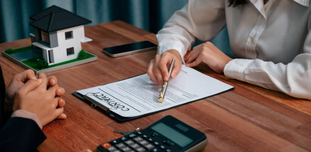 istock Reviewing house loan contract with agent using calculator. Enthusiastic 1483165189