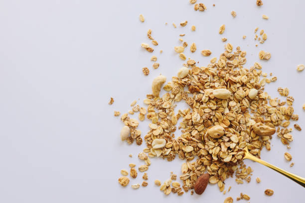 istock Granola on spoon isolated on white background, copy space. Healthy snack or breakfast concept - homemade granola with grains and nuts 1483166937