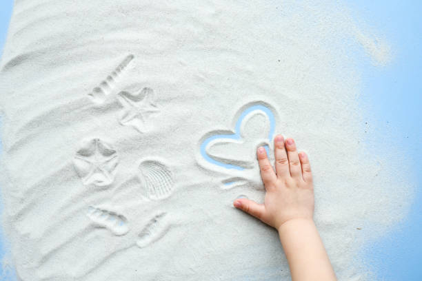 istock Child plays with sand, draws a heart 1483167185