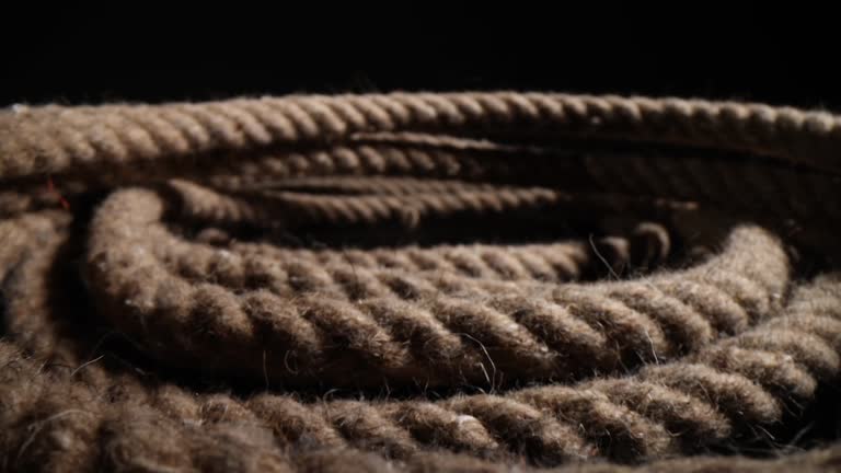 Closeup of nautical rope coiled into spiral on black background
