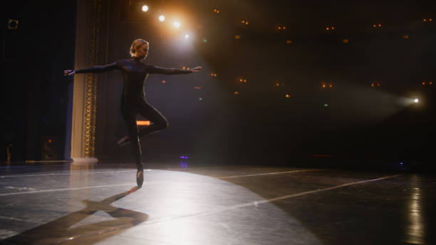 istock Ballerina practices ballet movements on theater stage 1483172281