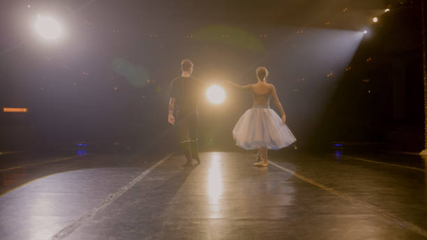 istock Ballet dancers come out from behind curtains and dance 1483172436