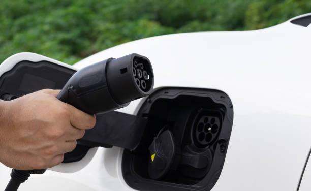 istock Progressive natural scenic of hand insert charging plug to EV car. 1483175512