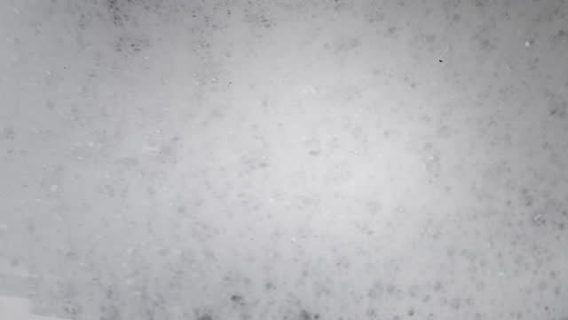 Close-up shot of bubbles from washing clothes in a washing machine. slow motion