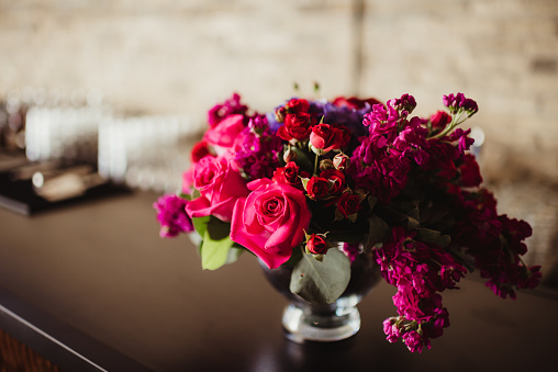 Brightly colored roses in a vase at a wedding