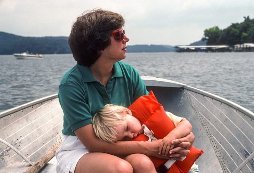 Lake of the Ozarks - Mother & Sleeping Son on Fishing Boat - 1990. Scanned from Kodachrome 64 slide.