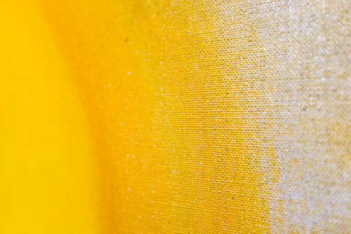 Partial close-up of an old oil painting in yellow with a background