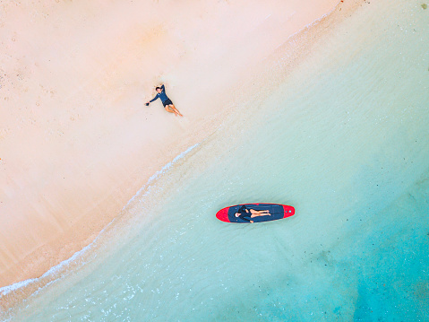 A couple enjoying a beach vacation at a tropical resort with a beautifully landscaped coastal pool at sunset. honeymoon destination at Thailand