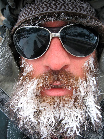 A man directly facing camera, with an icy beard and sunglasses.