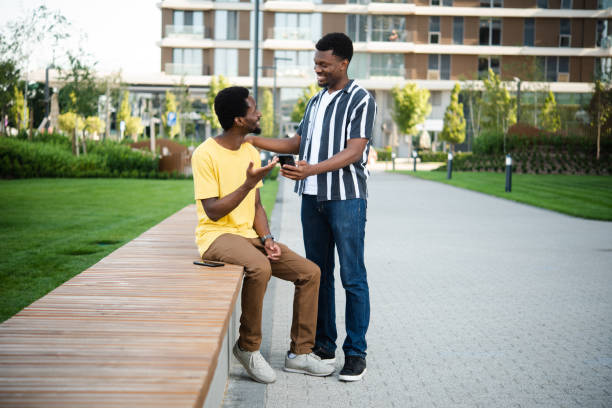 istock Two African American friends using smartphones and enjoying outdoors 1483197607