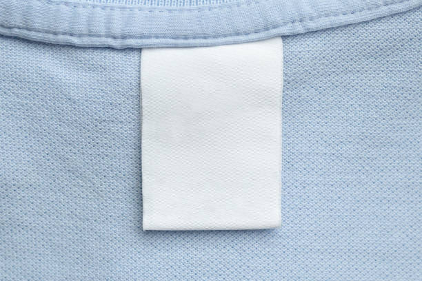 istock White blank laundry care clothes label on blue shirt fabric background 1483197784