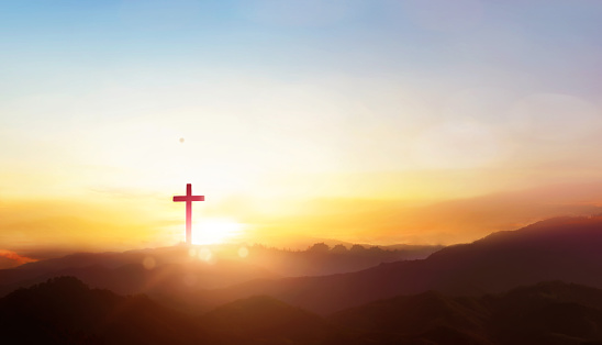 Christian cross on hill outdoors at sunrise