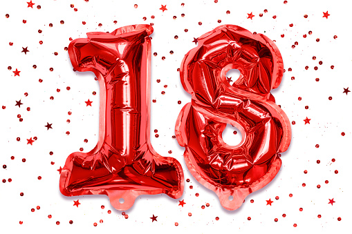 The number of the balloon made of red foil, the number eighteen on a white background with sequins. Birthday greeting card with inscription 18. Numerical digit, Celebration event.