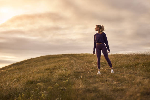 istock Sportswoman standing on hill in sunset 1483202218