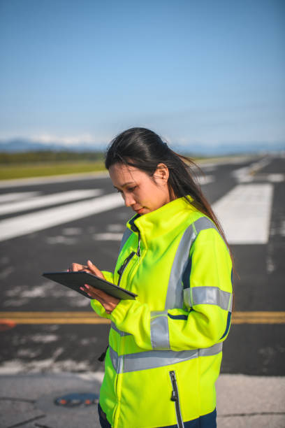 Asian Female Airfield Operations Officer Using A Digital Tablet