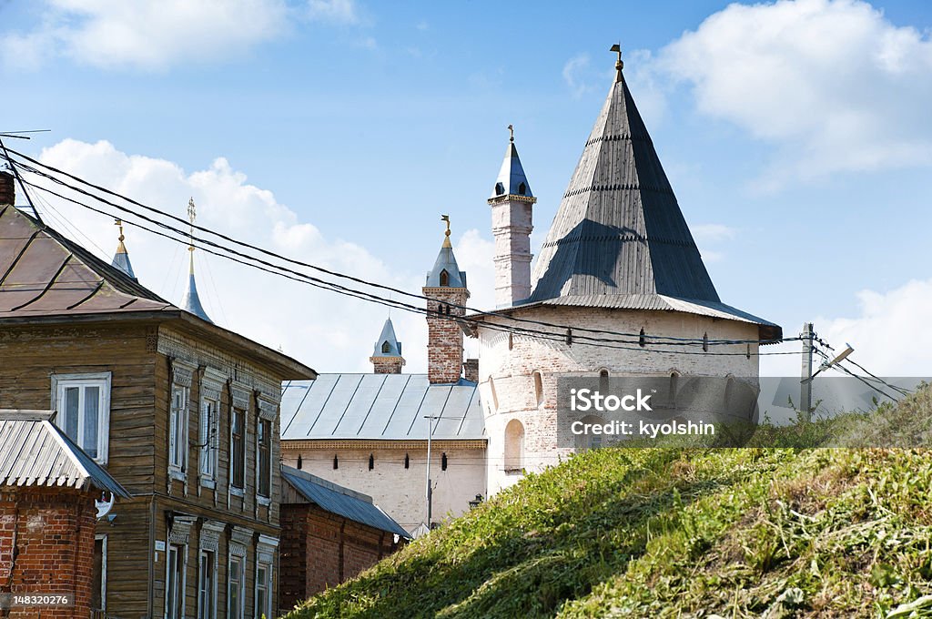 Kremlin tower in Rostov, Russia Rural scene with traditional russian house in foreground and kremlin tower with blue cloudy sky  in background. Rostov, Golden ring, Russia. Ancient Stock Photo