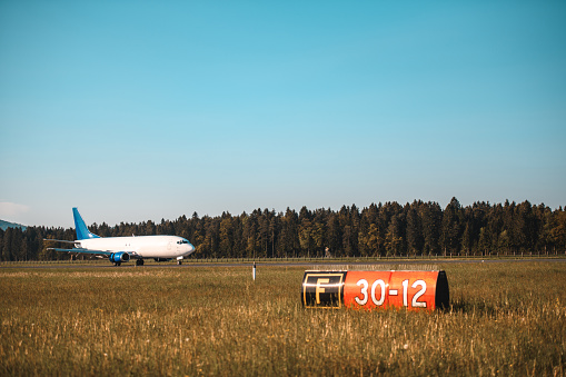 Commercial airplane landing at the airport. Closing in to the runway. Beautiful Alps in the background.