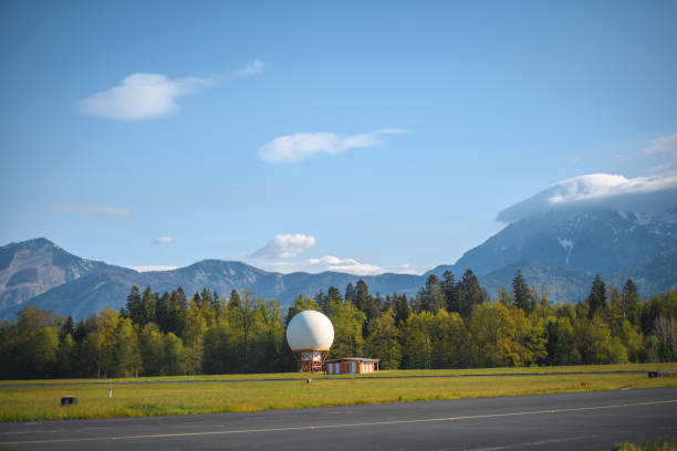 Doppler radar and a weather station next to an airport runway.