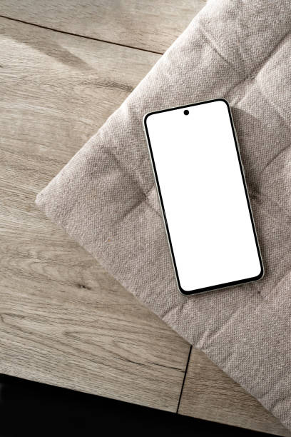 istock Mobile phone with empty screen mockup on neutral beige interior pillow and wooden desk, minimalist aesthetic Scandinavian style business branding design template, copy space 1483204346
