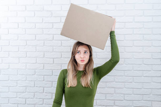 istock Attractive woman with parcel box on her head. Delivering a parcel 1483205699