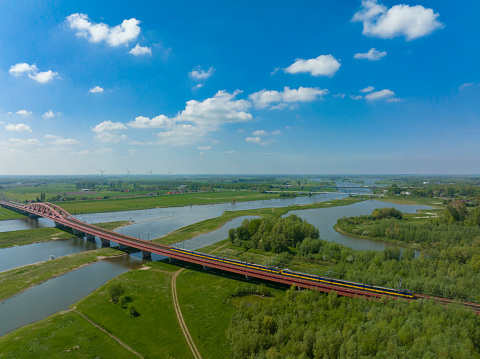 Hanzeboog train bridge over the river IJssel with high water level on the floodplains during summer near Zwolle, Overijssel, The Netherlands.