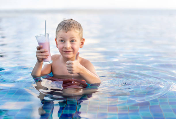 istock A little boy in the swimming pool drinks a milkshake. 1483207984