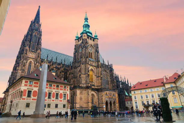 Photo of St. Vitus Cathedral at Prague Castle in Prague under a fantastic sunset. Tourists.