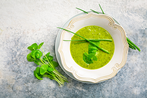 Healthy green soup with fresh spring plants, herbs, winter purslane, chives and ramson