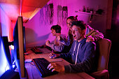 Teenage boys playing video game on desktop PC
