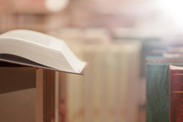 istock Image of open antique book on stack of books with glitter background. 1483214772