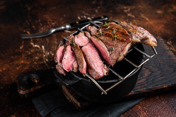 istock BBQ grilled Mutton fillet chop steaks, sliced lamb meat. Dark background. Top view 1483215775