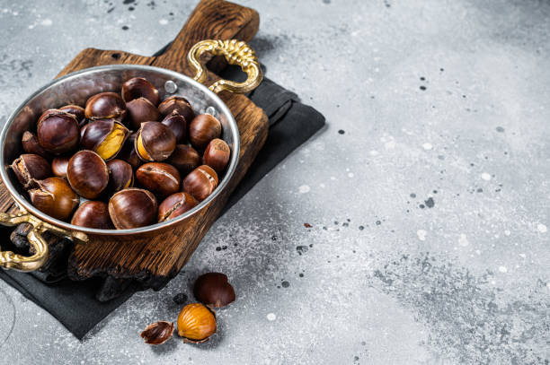 istock Cracked roasted chestnuts served in a skillet. Gray background. Top view. Copy space 1483215896