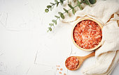 Himalayan salt raw crystals in wood spoon and bowl on white table background with copy space