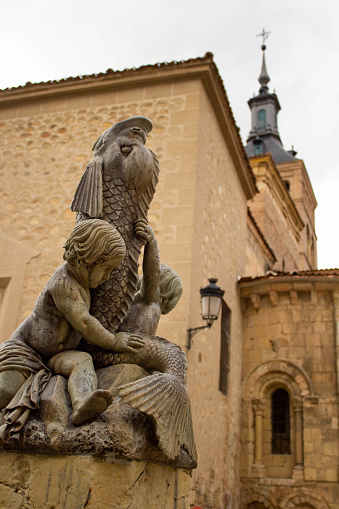 Statue of two boys holding a big fish in Segovia