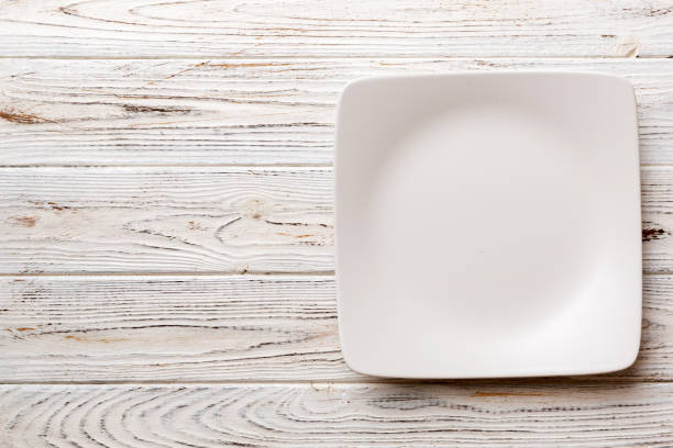 istock Top view of empty square plate on wooden background. Empty space for your design 1483220896