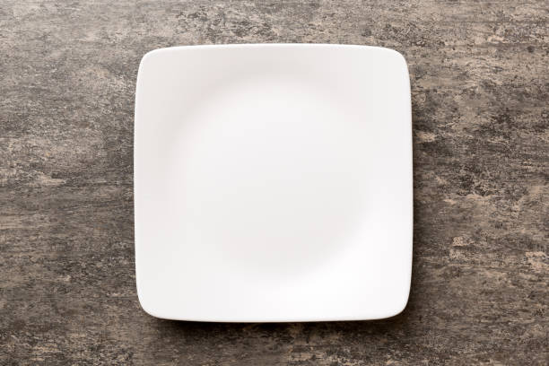 istock Top view of empty square plate on cement background. Empty space for your design 1483220907