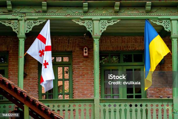 Georgian And Ukrainian Flags Hanging On The Balcony Of A Classic Georgian Wooden House In The Center Of Tbilisi In Georgia Stock Photo - Download Image Now