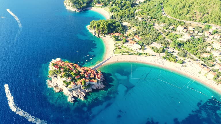 AERIAL VIEW of Sveti Stefan island. Sveti Stefan island on a beautiful summer day. Amazing island of Sveti Stefan with houses in Montenegro