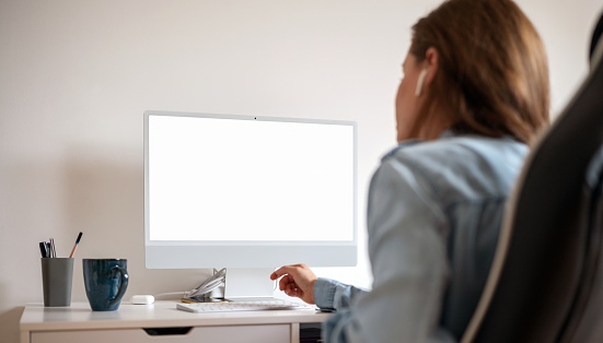 Blank screen of computer monitor and woman participating in online meeting.