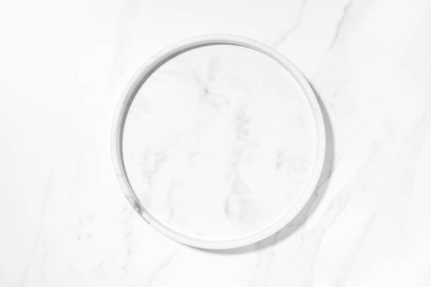 Beauty cosmetics product presentation flat lay mockup scene with white marble circle plate on white marble table with copy space. Trendy sunlight,  top view. Studio photography.
