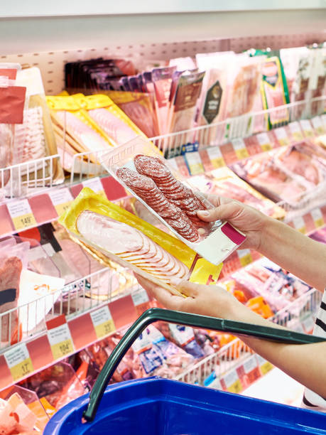 istock Sliced sausage and pork ham in hands in store 1483225117